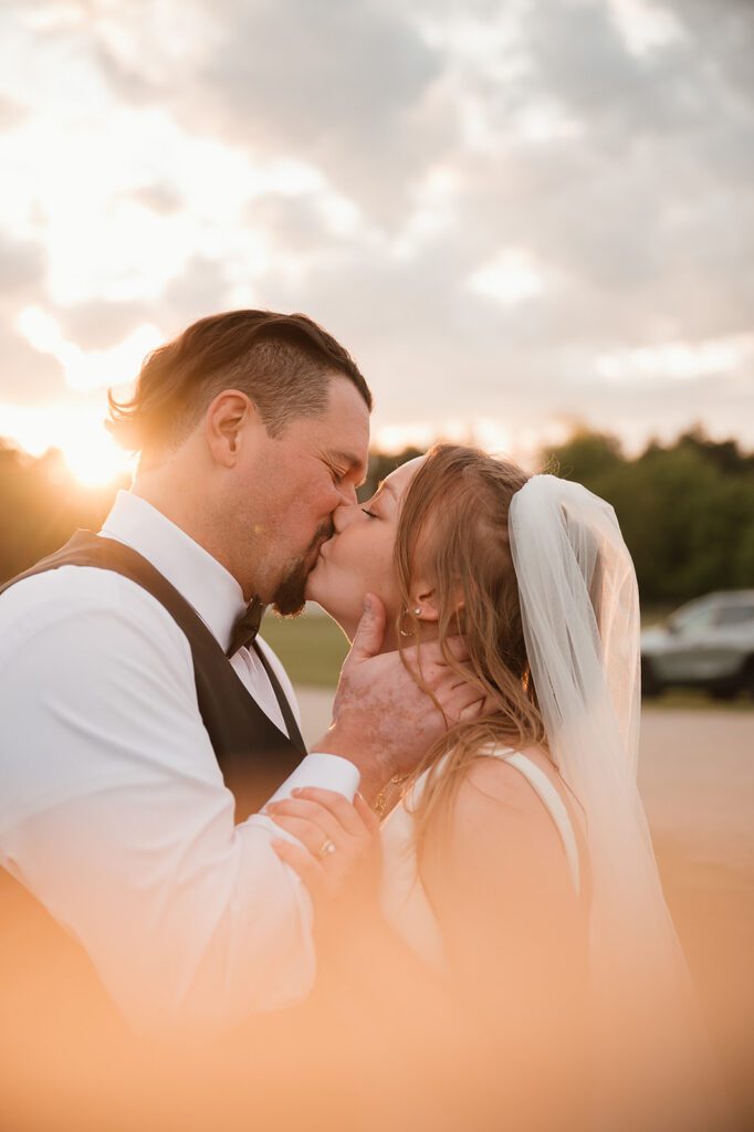 A couple kissing at sunset on the grounds at Jennings Holler