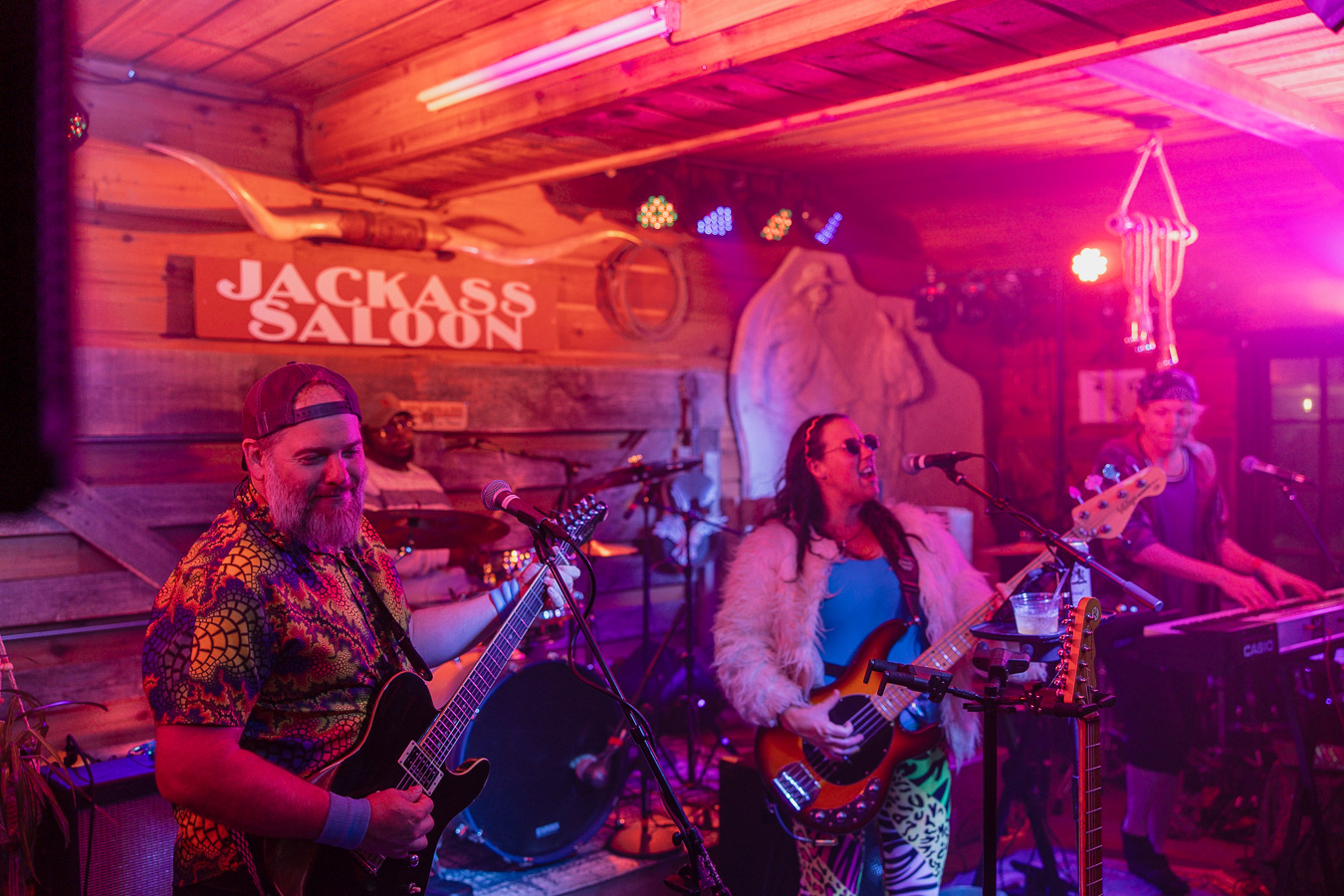 A band playing under the Jackass Saloon sign