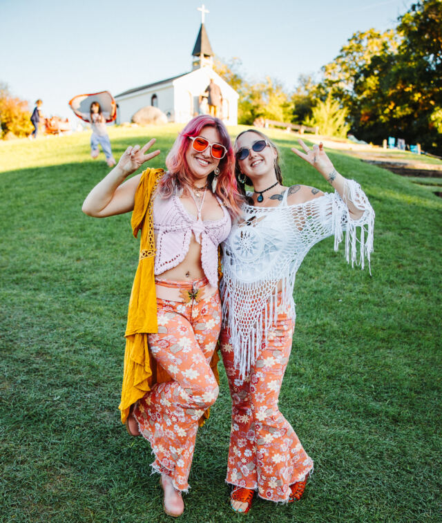 Two friends in festival outfits on the hill below Saint Rose Chapel